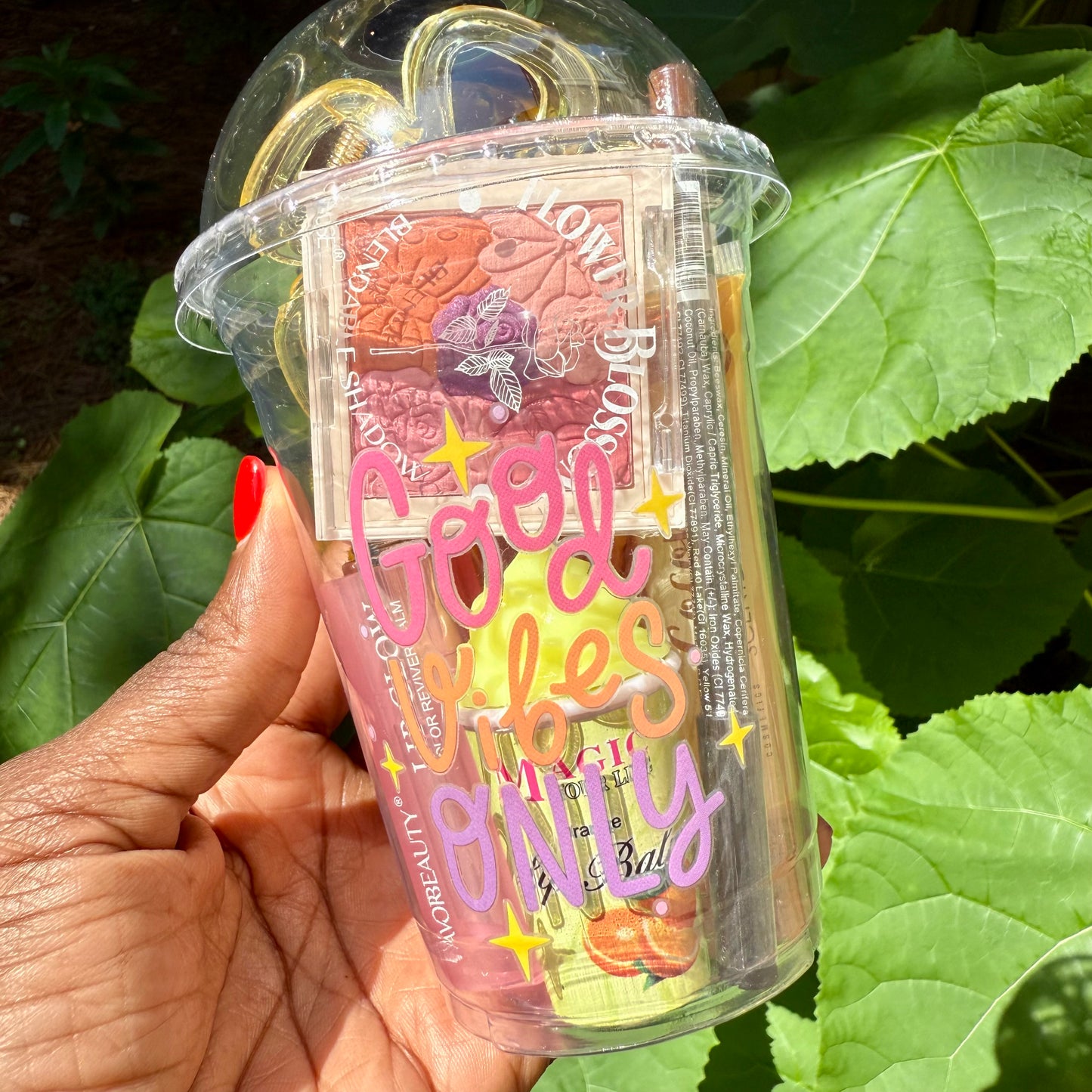 clear plastic container with colorful text and makeup products