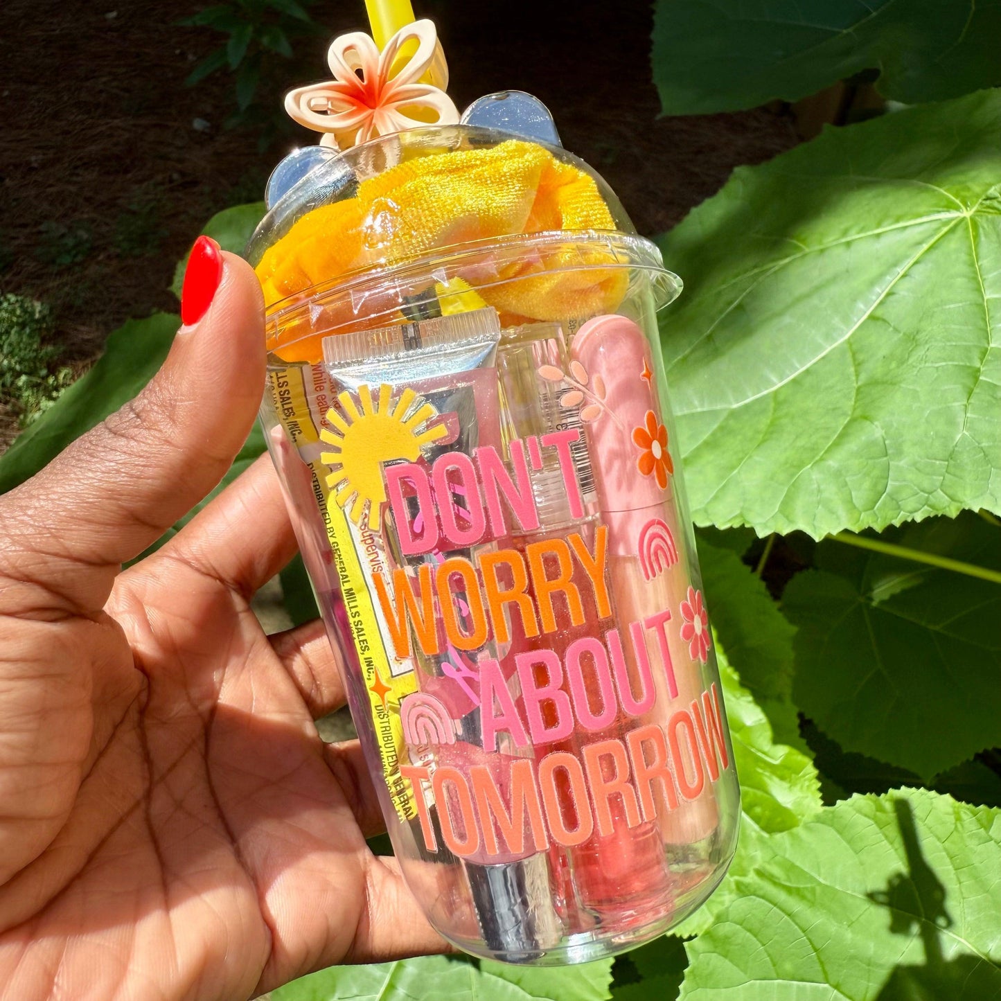 Clear cup with colorful straw and beauty products