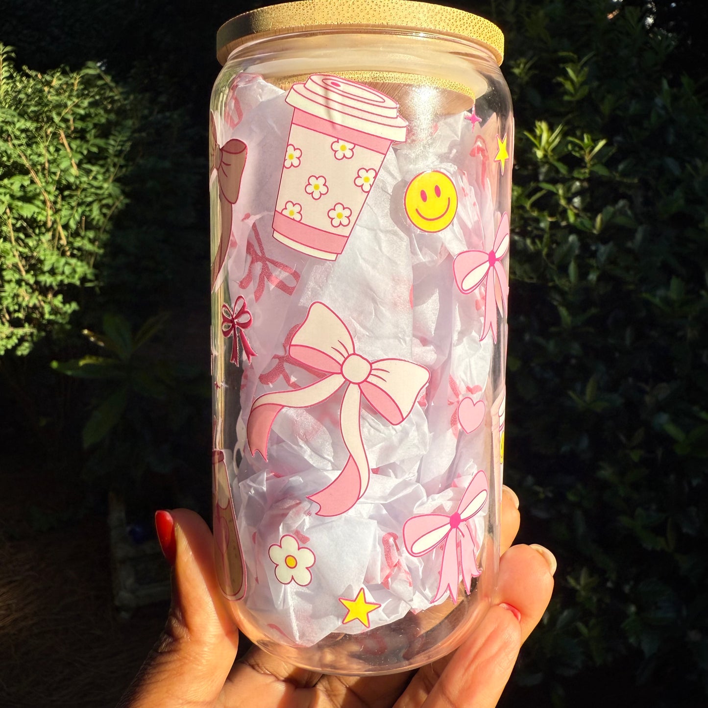 Clear jar with pink bows, flowers, and other decorative elements