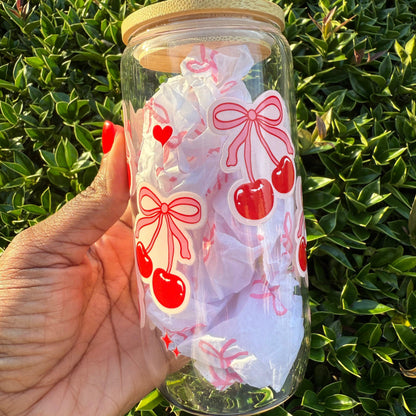Glass jar with decorative stickers of bows and cherries 